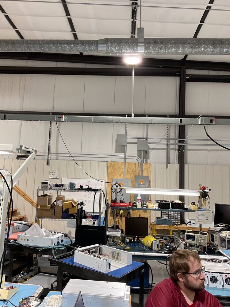 Industrial / commercial workspace — ductwork, panel, and conduit on plywood backboard