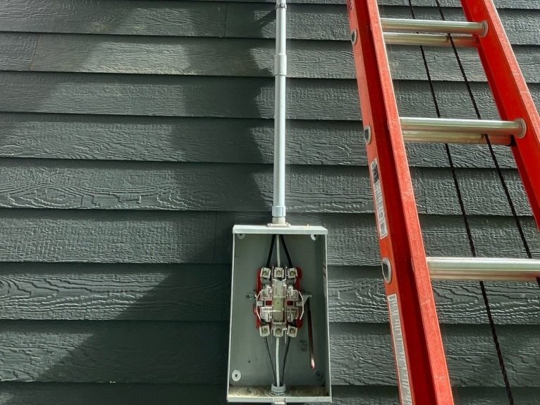New electrical service mast and meter socket installed on a home